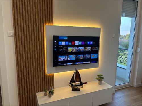 a living room with a television on a wall at Apartment Aqua Serena in Palić