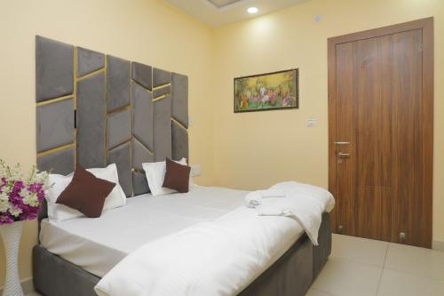 a bedroom with a large bed and a wooden door at hotel vcr inn in Ghaziabad