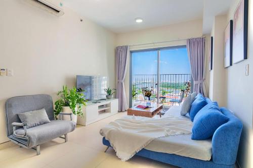 a bedroom with a bed and a chair and a window at Masteri Thao Dien Riverside Apartment in Ho Chi Minh City