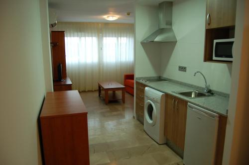 a kitchen with a sink and a washing machine at Apartamentos Aixa II in Caravaca de la Cruz