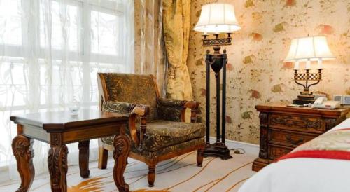 a bedroom with a desk and a chair and a lamp at Hangzhou The First World Hotel in Hangzhou
