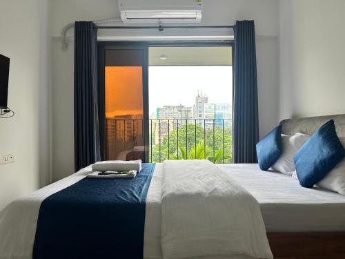 a bedroom with a bed with a large window at Zenith Suites & Service Apartments - Powai in Mumbai