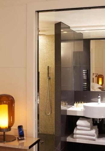 une salle de bain avec un lavabo et une douche dans l'établissement Hotel Opéra Richepanse, à Paris