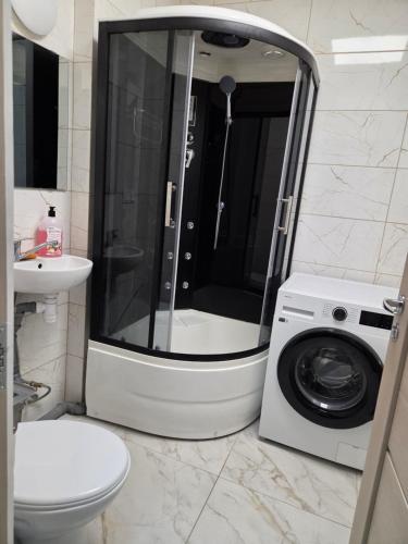 a bathroom with a shower and a washing machine at Pie Parka in Alūksne