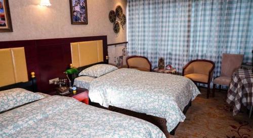a hotel room with two beds and chairs at Changsha Huatian Hotel in Changsha