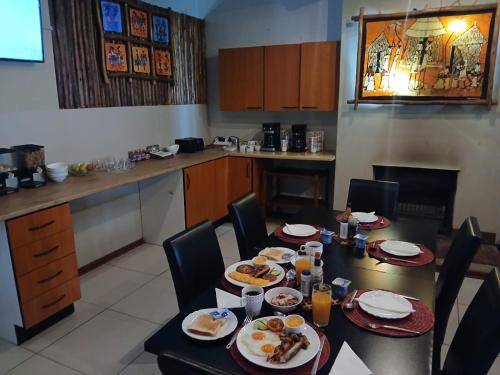 a dining room with a table with plates of food at The Comfort Zone - Mthatha in Mthatha
