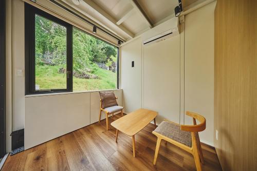 a room with a table and a chair and a window at Sakanaya Stay in Kona