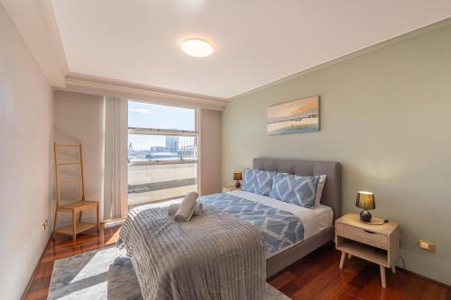 a bedroom with a bed and a large window at Cosmopolitan Charm in Central Sydney in Sydney