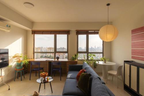 a living room with a blue couch and a table at The Vista Masteri Thao Dien N-Stay Apartment in Ho Chi Minh City