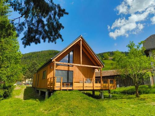a wooden cabin with a gambrel roof at Lodge de la WEISS in Lapoutroie