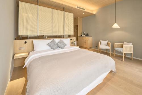 a bedroom with a large white bed with two pillows at The Yard Boutique Hotel Shanghai 一隅酒店上海虹桥漕河泾店 in Shanghai
