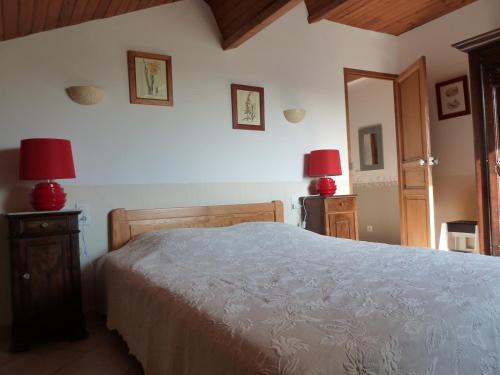 une chambre avec un lit et deux lampes au mur dans l'établissement Les Tournesols, à Saint-Andiol