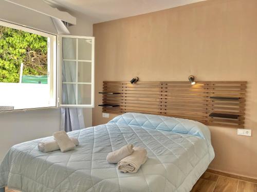 a bedroom with a large bed with towels on it at Gregal - Castell Sol - Arenal de Castell in Arenal d'en Castell