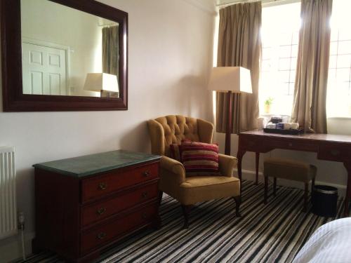 唐克斯特的住宿－INGRAM ARMS HOTEL, HATFIELD，酒店客房配有椅子、书桌和镜子