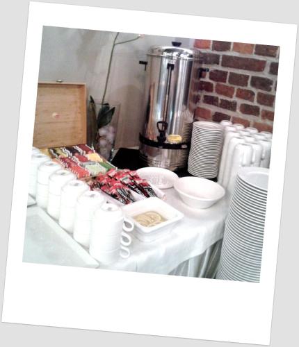 a table with white cups and plates and a blender at Hotel Kamienica in Opole