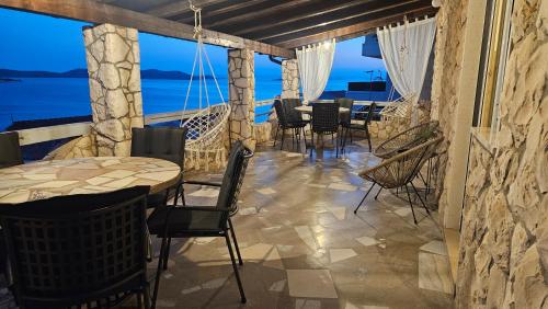 a restaurant with tables and chairs and a view of the ocean at Villa Marica & Joso in Drage