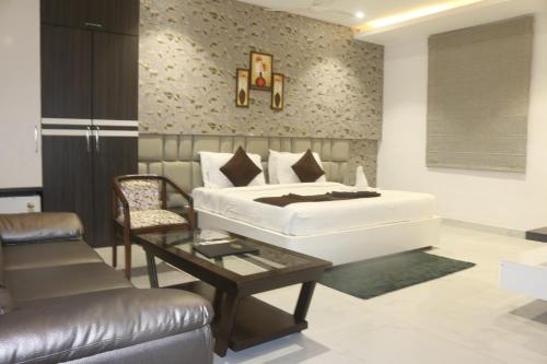 a bedroom with a bed and a chair and a table at Royal Bliss in Patna