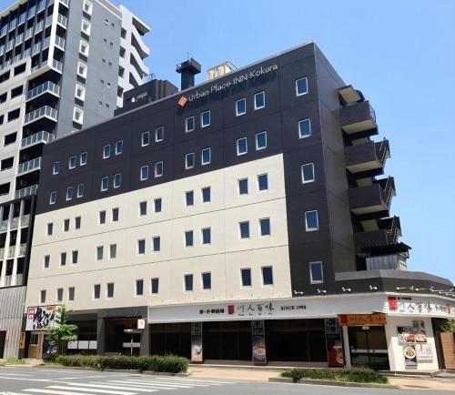 a large building with a balcony on top of it at Urban Place Inn Kokura in Kitakyushu