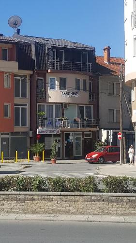 a building on the side of a street with a red car at Apartments Ohrid Lake in Ohrid