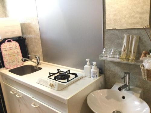 a bathroom with a sink and a stove at Apartment Hotel Mimoza - Vacation STAY 90043v in Sumoto