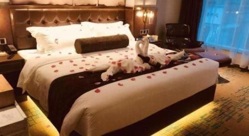 a bed with red hearts on it in a hotel room at James Joyce Coffetel Chengdou Wuqing Wanda Plaza in Chengdu