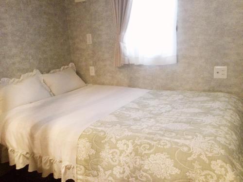 a bedroom with a white bed with a window at Apartment Hotel Mimoza - Vacation STAY 92095v in Sumoto