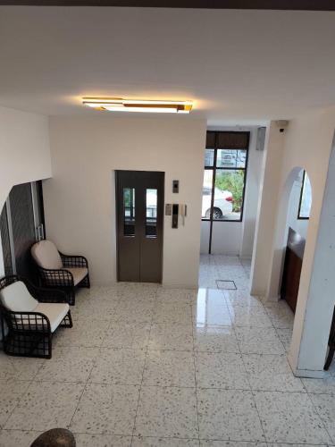 a hallway with chairs and a door in a building at Seaside Palace Hotel in Koh Samui 