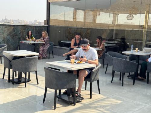 a man sitting at a table in a restaurant at Comfort Sphinx & Pyramids Inn in Cairo