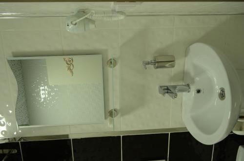 a bathroom with a white sink and a picture on the wall at Sinop Dolunay Hotel in Sinop