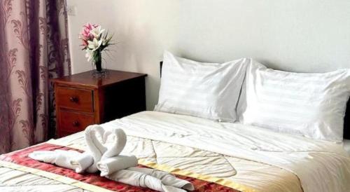 a bed with two towels and a vase of flowers on it at Rueangrat Hotel in Ranong