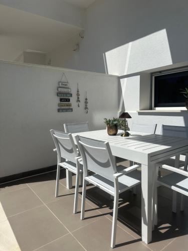 a white dining room with a white table and chairs at Casa D'oro in Orihuela