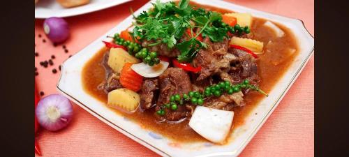 a plate of food with meat and vegetables on a table at MOTEL Đồng Khởi in Giồng Tú Ðiền