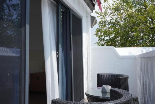a table and chair on a porch with a window at Xiamen Gulangyu Heitan Hotel in Xiamen