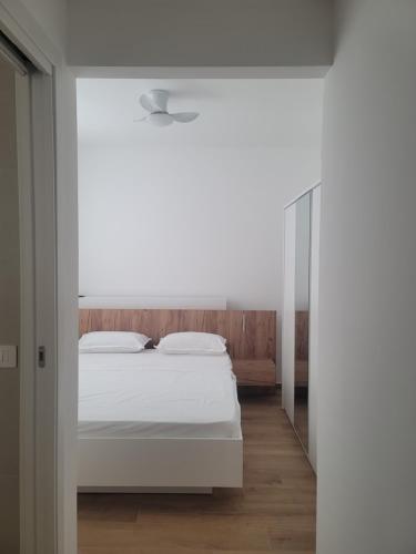 a bedroom with a white bed and a mirror at Merysuite Campomarino lido in Campomarino