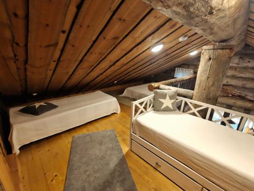 a room with two beds in a log cabin at Isokelo Log Apartments in Salla