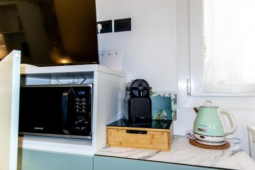 a kitchen counter with a microwave and a tea kettle at Bolhome Botanique-NR the Center in Bologna
