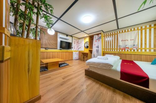a bedroom with a bed and a tv in it at SHIN Hotel 80th Stadium Korat in Sathani Phu Khao Lat