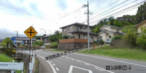 un camino vacío con una señal a un lado de la carretera en 布施温泉ステイ　イースト, en Saku