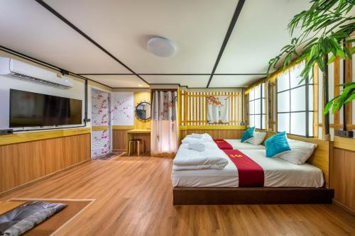 a bedroom with a bed and a flat screen tv at SHIN Hotel 80th Stadium Korat in Sathani Phu Khao Lat