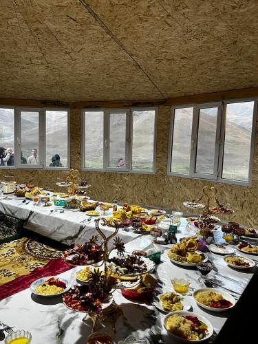 a long table with many plates of food on it at Taasir Yurt Camp in Dzhangyaryk