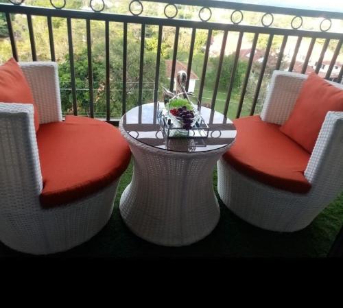 a balcony with two chairs and a table on a balcony at Ssumo Comfy Stays in Kisumu