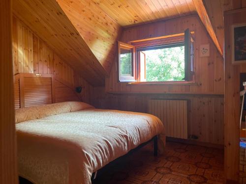 a bedroom with a bed in a wooden cabin at La Baita di Nyra in Pizzoferrato