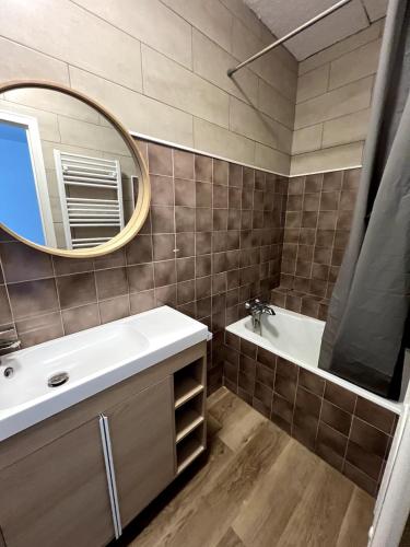a bathroom with a sink and a mirror at Confort appart in Oyonnax
