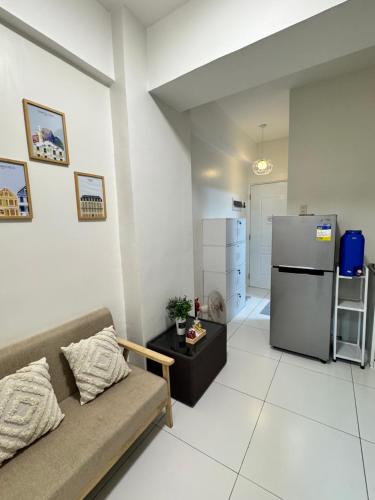 a living room with a couch and a refrigerator at SM Naga City 2BR River view Balcony with Fiber Internet in Naga
