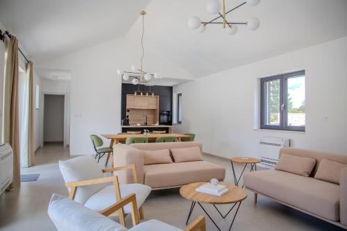 a living room with couches and tables and a kitchen at Summer Breeze in Gornji Humac