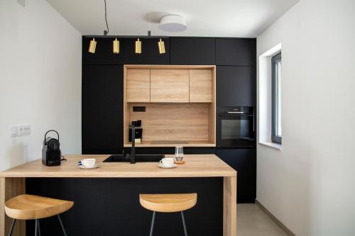 a kitchen with black walls and a wooden counter with stools at Summer Breeze in Gornji Humac