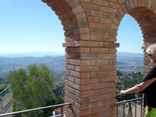 a woman standing on a balcony looking out at the mountains at Villa Caporotondo in Pisticci