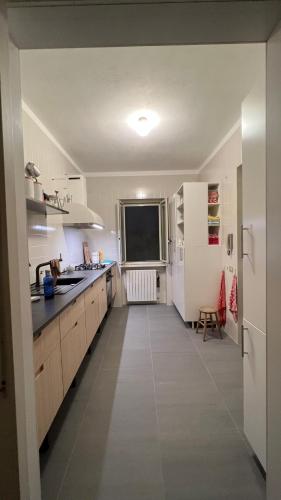 a large kitchen with white cabinets and a television at Villa Caporotondo in Pisticci