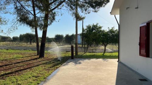 a walkway leading to a field with trees and a building at Villa Caporotondo in Pisticci
