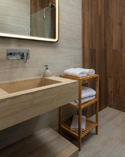 un bagno con lavandino, specchio e asciugamani di Tic Tac Toe Residence a Durrës